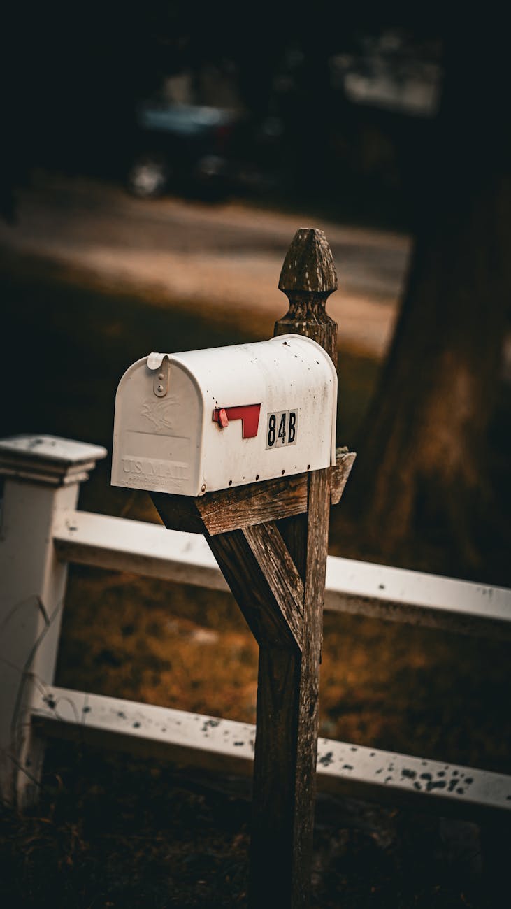 rustic white mailbox on wooden post
